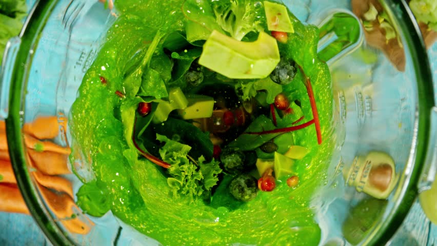 Super slow motion of mixing pieces of fruit and vegetables in blender, camera movement, top shot. Filmed on high speed cinema camera, 1000 fps.