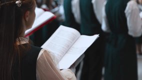 Church choir concert in cathedral, christian choral artists singing, group of European boys and girls singing in a chorus, students and choristers in white and green uniform performing on stage  - Powered by Shutterstock - Get 15% off with code: PIKWIZARD15