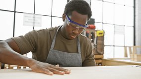 Focused african american man wearing safety glasses works meticulously in a woodworking workshop - Powered by Shutterstock - Get 15% off with code: PIKWIZARD15