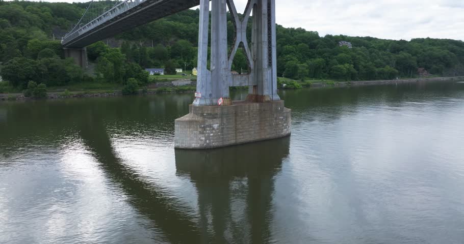 Aerial video of the Franklin Delano Roosevelt Mid-Hudson Bridge over the Hudson River, Poughkeepsie NY.  Panning, pan, camera movement around west tower. 		