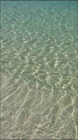 Transparent ocean wave at sandy beach, close up shot. High quality 4k footage