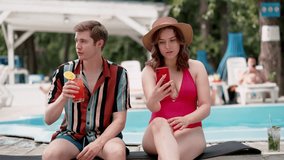 Couple enjoying by pool, taking a selfie, sipping tropical drinks, creating happy memories - Powered by Shutterstock - Get 15% off with code: PIKWIZARD15