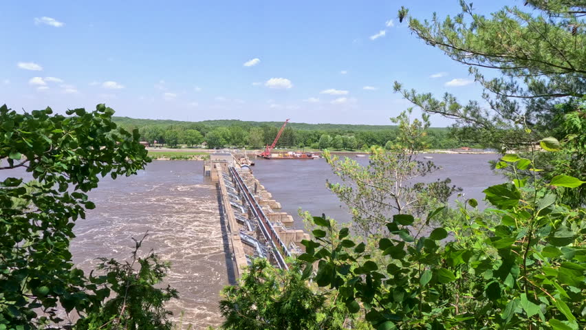 Peeking through the trees with views of a large dam on the Illinois River. Located within Starved Rock State Park in LaSalle County, Illinois. Slow motion views.