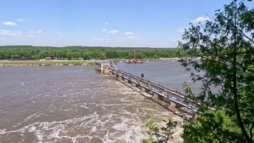 Peeking through the trees with views of a large dam on the Illinois River. Located within Starved Rock State Park in LaSalle County, Illinois. Slow motion views.