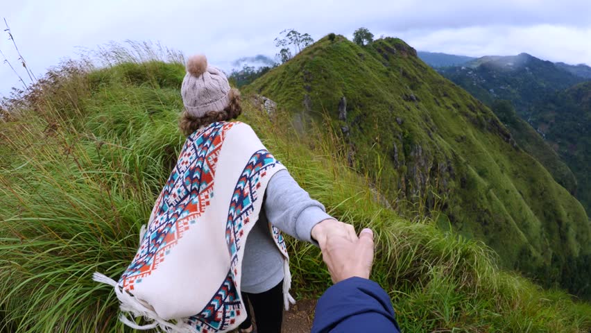 Follow me couple travelers on top green mountain island. Top offers breathtaking views for active tourists. Woman leads guy to top Asian highlands. Romantic trip and unforgettable moments at its best