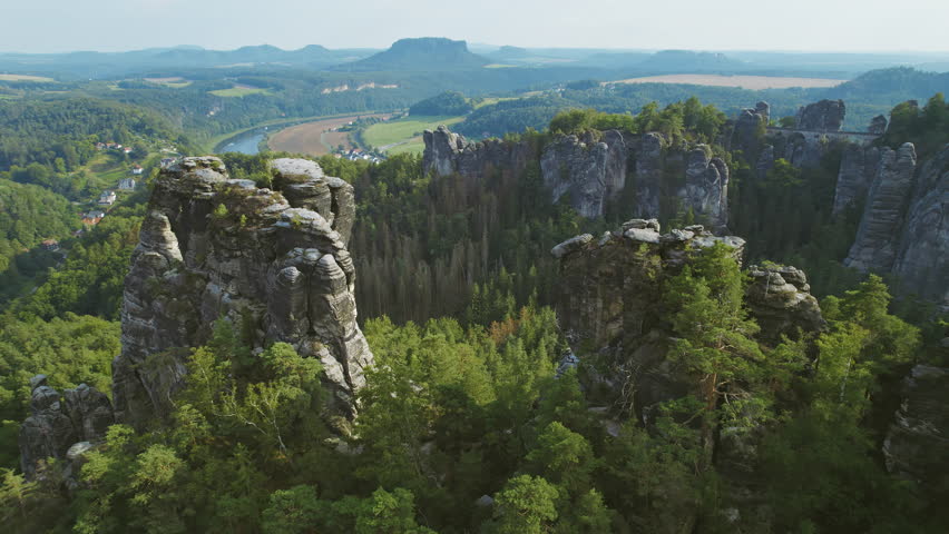 Scenic landscape with rock pillars and green forest in Saxony Switzerland, Germany. Aerial view of Elbe river and wooden Bastei Bridge.