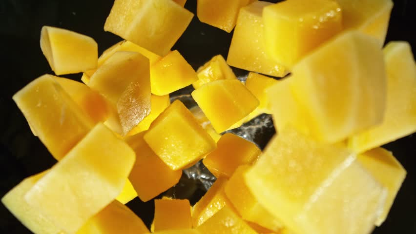 Super Slow Motion of Falling Mango Pieces into Water. Filmed on High Speed Cinema Camera, 1000fps, Placed on High Speed Cine Bot. Camera in Motion, Following Objects.