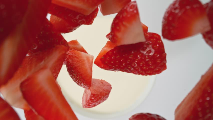 Super Slow Motion of Falling Strawberries into Cream. Filmed on High Speed Cinema Camera, 1000fps, Placed on High Speed Cine Bot. Camera in Motion, Following Objects.
