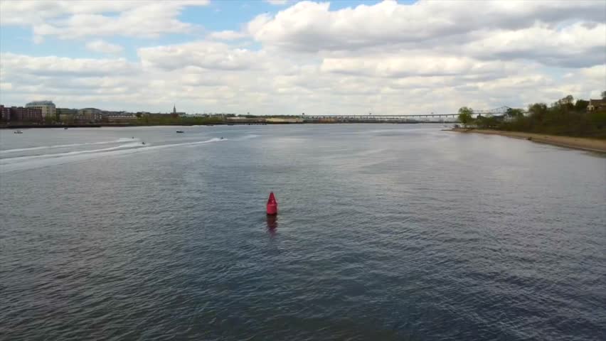 A ladscape scene of sea with speed boats and green coast with gray cloudy sky for wallpaper