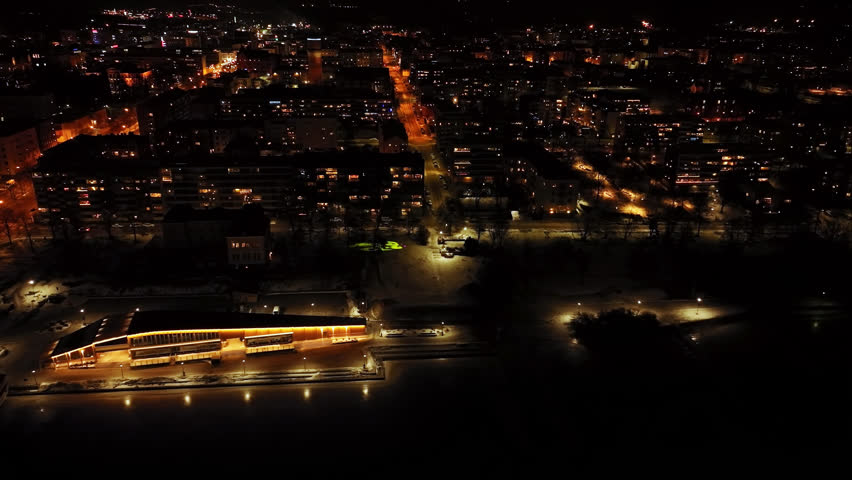 Aerial tracking shot in front of the illuminated Vaasa city, night in Finland