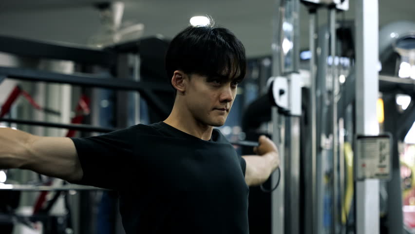 Healthy man is overhead resistance band arms stretching for workout to strengthen and increase mobility and flexibility upper body in fitness gym