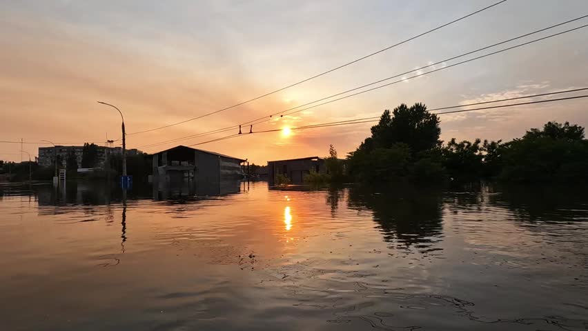 Flooded streets in Kherson town with beautiful sunset at background. Explosion of dam on Dnipro river in city of Novaya Kakhovka. Consequences of detonation of Kakhovka Hydroelectric Power Station