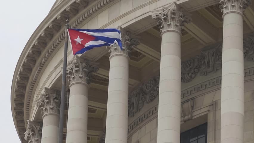 Cuban flag waving in wind at building in Havana, Cuba. slow-motion