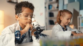Young school boy and girl explore sample under microscope, conduct lab research - Powered by Shutterstock - Get 15% off with code: PIKWIZARD15