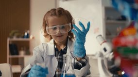 Girl in safety goggles mixes liquids in lab flask, observes chemical reaction - Powered by Shutterstock - Get 15% off with code: PIKWIZARD15