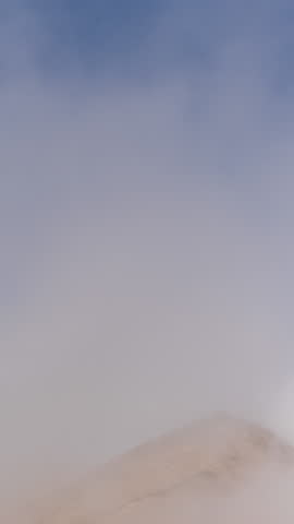 Vertical video. Timelapse At the Top of a Deserted Mountain as Clouds Swiftly Arrive, Enveloping Everything Around.