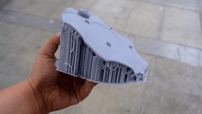 Man holding in hand an object created on a 3D printer from hardened rubber. SLA technologies. 3D printer prototyping technology - Powered by Shutterstock - Get 15% off with code: PIKWIZARD15