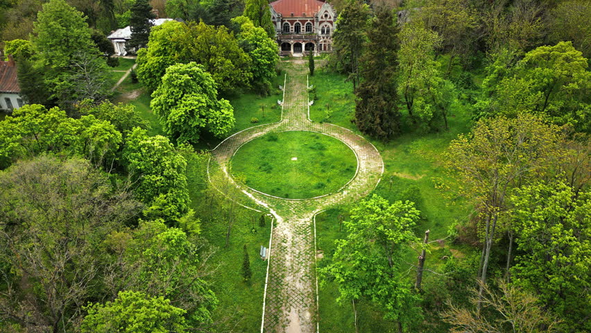 Drone view of the Pommer Mansion in Taul, Moldova. Old abandoned building with greenery around it and garden in front of it