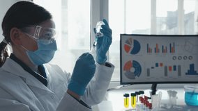 A scientist in a lab conducts experiments with a syringe, focusing on analysis, biotechnology, precision, innovation, and research. Wearing gloves, a mask, and working with dedication - Powered by Shutterstock - Get 15% off with code: PIKWIZARD15