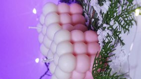 vertical video. Cute white and pink Bubble candles on purple background. items for New Year's interior decor. - Powered by Shutterstock - Get 15% off with code: PIKWIZARD15