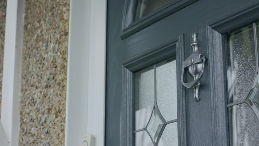 A closeup footage of adult male hand using the door knocker to knock the door