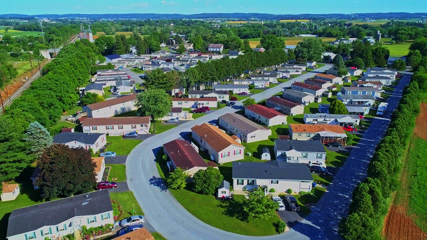 An Aerial View of a Well Kept Mobile, Manufactured, Prefab Home Park of Single Wide and Double Wide Houses on a Sunny Day