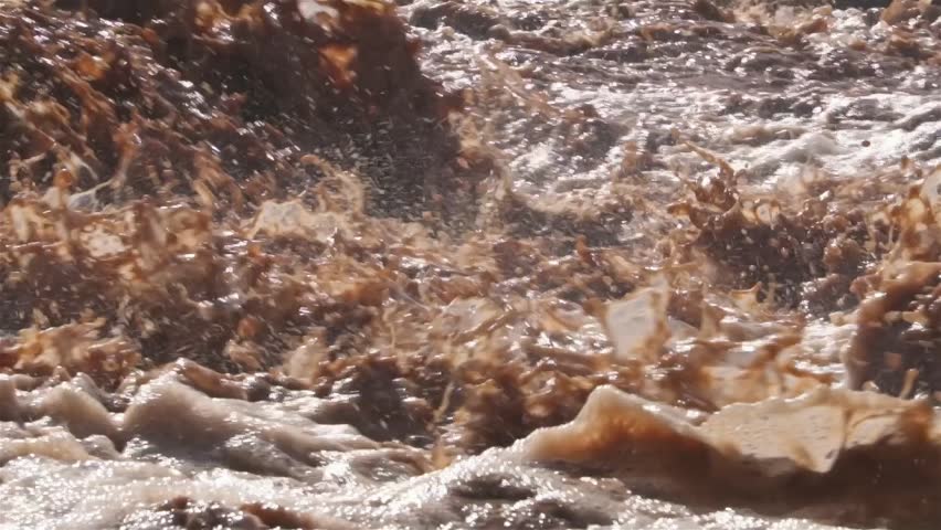 Muddy flooded river splash after torrential rain storm