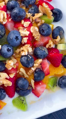 Healthy breakfast fresh fruits blueberries, raspberries, kiwis, tangerines, strawberries and nuts with yogurt. Healthy lifestyle. High quality 4k footage
