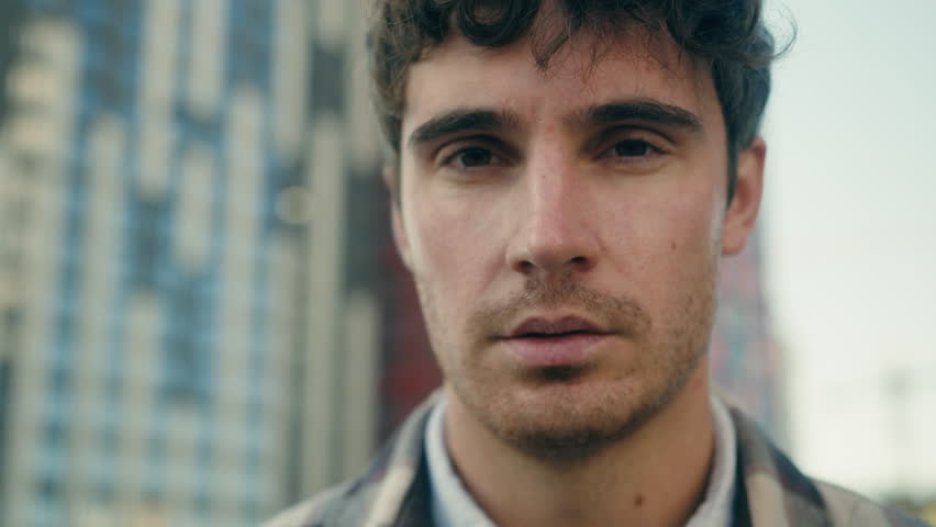 Close up portrait outdoors Caucasian adult 30s man millennial guy serious face looking upset sad worried unhappy gaze male tourist travel outside real estate agent businessman client in city downtown