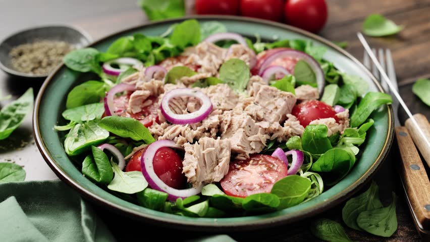 Canned tuna salad with tomatoes lambs lettuce corn salad and onions, stock video 4k