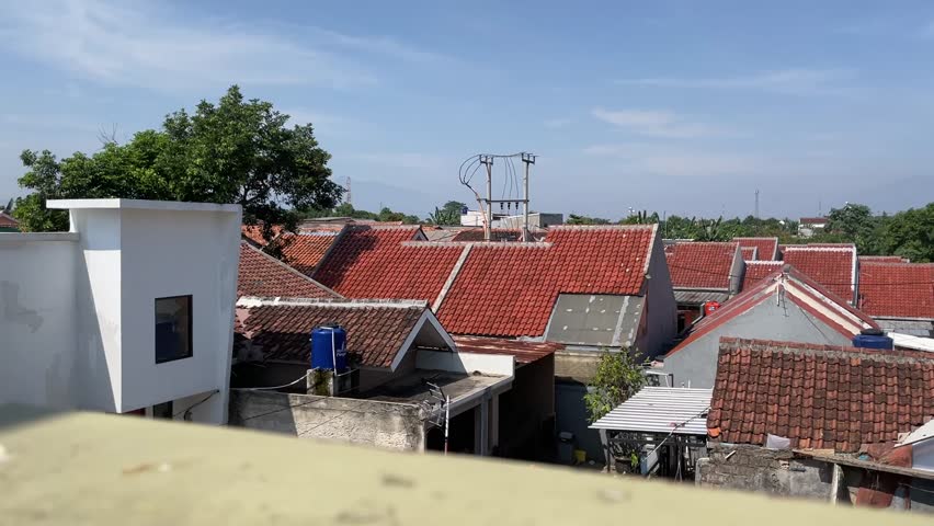 a densely populated village in the Depok area of ​​West Java, Indonesia. You can see lots of houses without spaces with almost the same shape. There are several trees to keep the air fresh (2024)