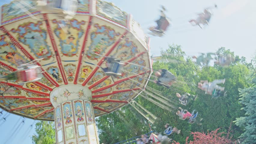 Roller coaster Ride against blue sky. Roller coaster in the amusement park. Cheerful entertainments in park of attractions. Vertical video