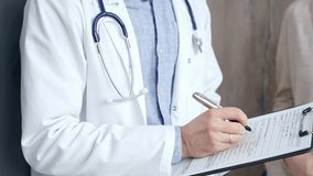 Healthcare professional doctor is focused on updating medical charts on a clipboard. Male unrecognizable physician at work. Medicine and pharmacy - Powered by Shutterstock - Get 15% off with code: PIKWIZARD15