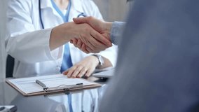 Doctor and patient handshake in clinic setting above the glass table. Medicine concept trust and agreement - Powered by Shutterstock - Get 15% off with code: PIKWIZARD15