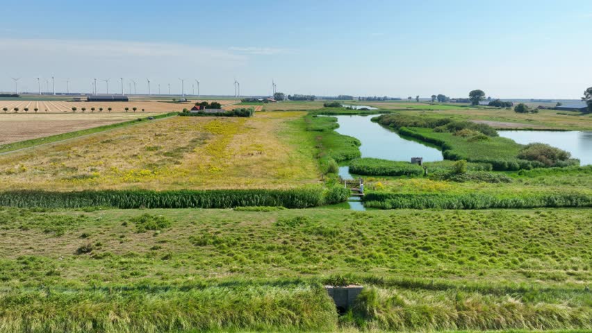 An aerial drone view of a river and a beautiful green landscape in Zeeland, Netherlands