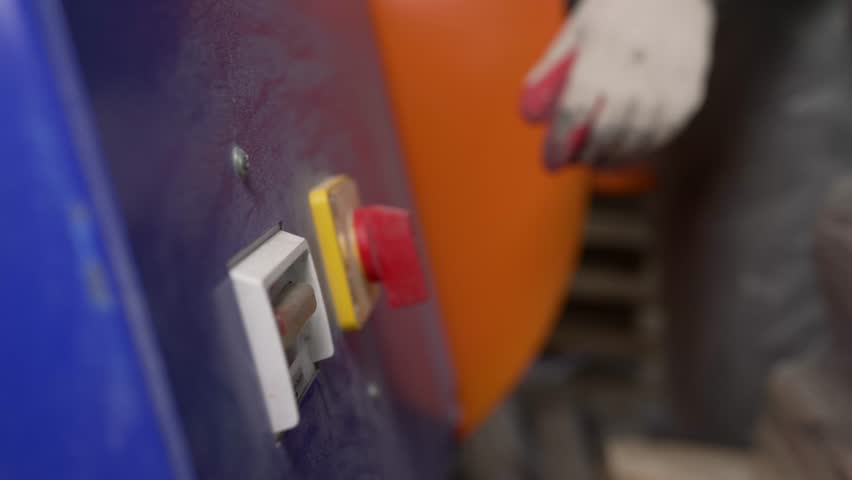 Close-up, hand turns on a concrete mixer. A hand presses a button on a concrete mixer.