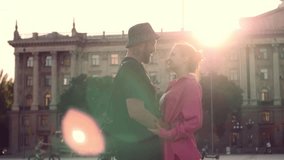 Portrait of beautiful young couple kissing and hugging at city street at sunlight background. Meeting a couple in love. Love story, romantic atmosphere, true feelings. Slow motion HD video