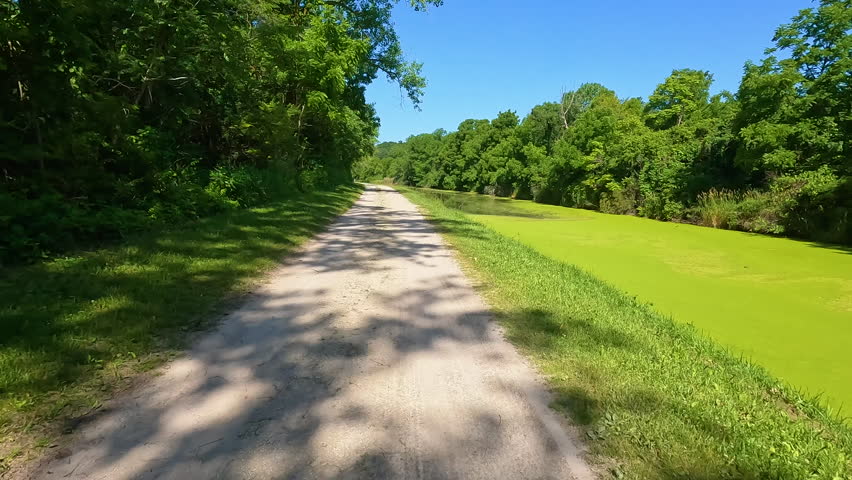 Hiking a dirt trail along a canal covered in algae. Located along the Historic Illinois and Michigan Canal, on the I and M Canal State Trail system.