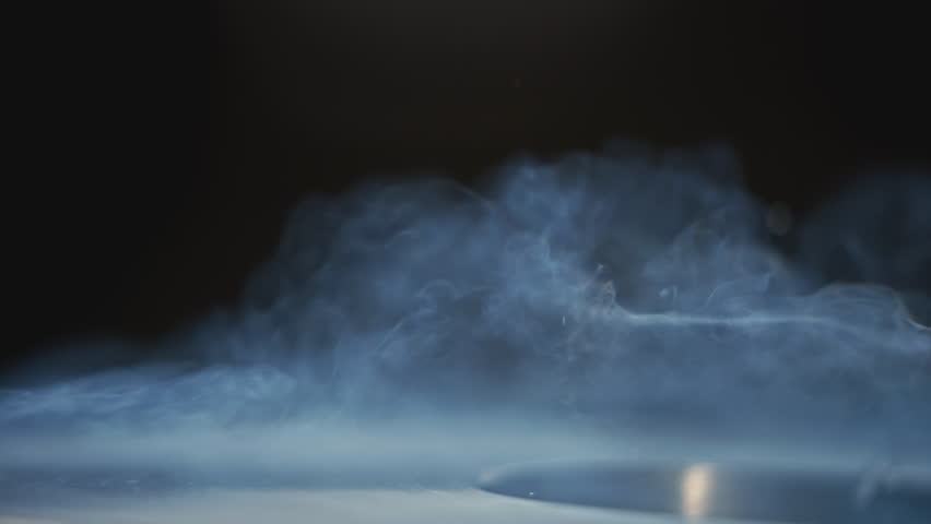 Hot water being poured out of bucket. Stock footage. Close-up of jet of water pouring out of small bucket. Hot clean water is poured from ladle into metal container with steam