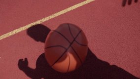 Side view of dynamic and active sportsman dunking basketball at center of orange court. Skilled young player wearing blue sneakers practicing outdoors in preparation for upcoming competition. - Powered by Shutterstock - Get 15% off with code: PIKWIZARD15