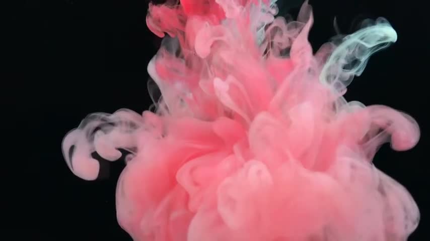 Drop of vivid ink descends gracefully into the water, instantly blooming like a slow-motion explosion. The ink expands and curls, creating swirling patterns that resemble plumes of colorful smoke.