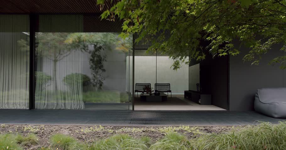 An inviting modern home terrace features large glass panels, contemporary furniture, and vibrant green foliage, blending comfort with nature.Modern Home Terrace with Elegant Interior and Lush Greenery