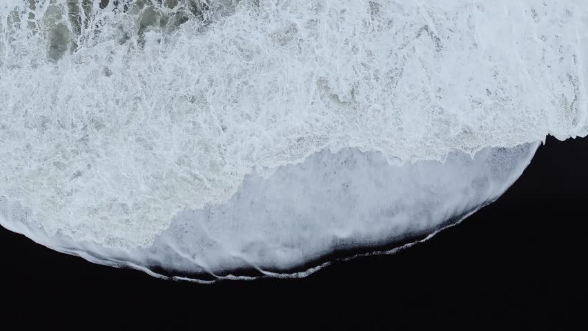 Aerial View of Powerful Atlantic Ocean Waves Crashing on Iceland Black Sand Beach.