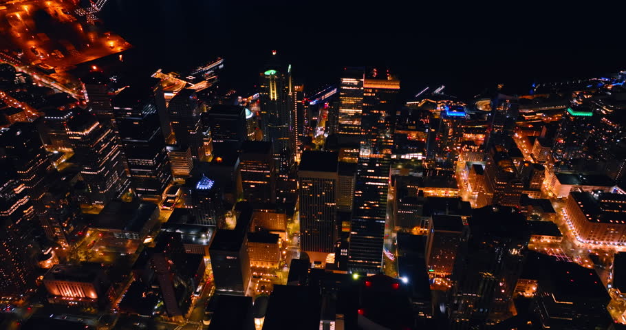 Luminous panorama of Seattle, Washington, US at night. Drone rising over the well-lit streets of the city.