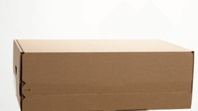 A cardboard box with a white label rotates on a white background. Cardboard box on white. - Powered by Shutterstock - Get 15% off with code: PIKWIZARD15