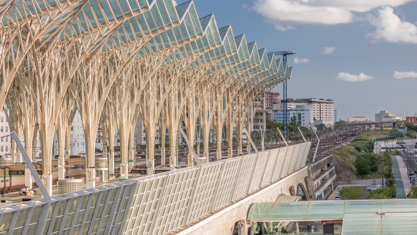 Lisbon Oriente Train and Bus Station aerial timelapse where steel and glass trees interlock to form a continuous system of transparent roofs. Trains arrive and departure. Lisbon, Portugal