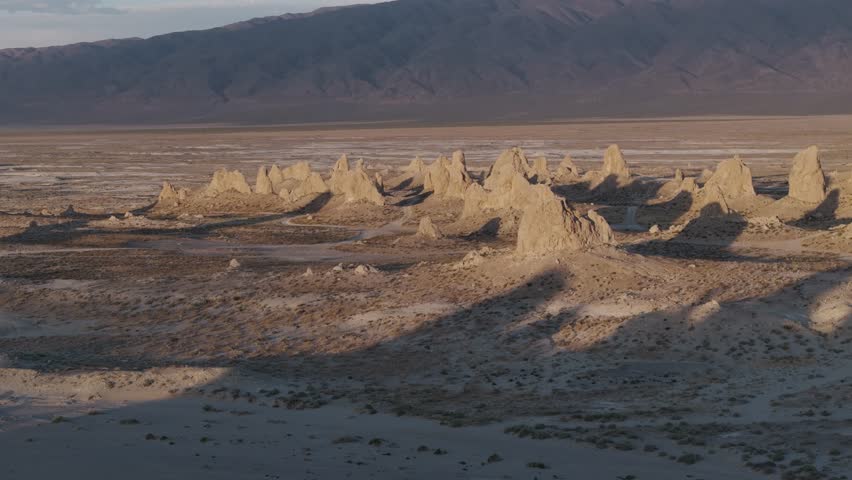 Golen hour aerial orbit of Trona Pinnacles, California in the Mojave desert during summer.