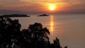 Aerial drone footage of a stunning sunset over Lake Kivu in Rwanda. Captures the serene water reflections, silhouetted islands, and vibrant colors of the sky in a tranquil setting. - Powered by Shutterstock - Get 15% off with code: PIKWIZARD15