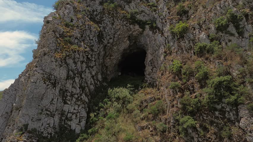 Cliffs with large caves on top of a mountain range covered with trees. Aero drone view. 4k high quality stock video