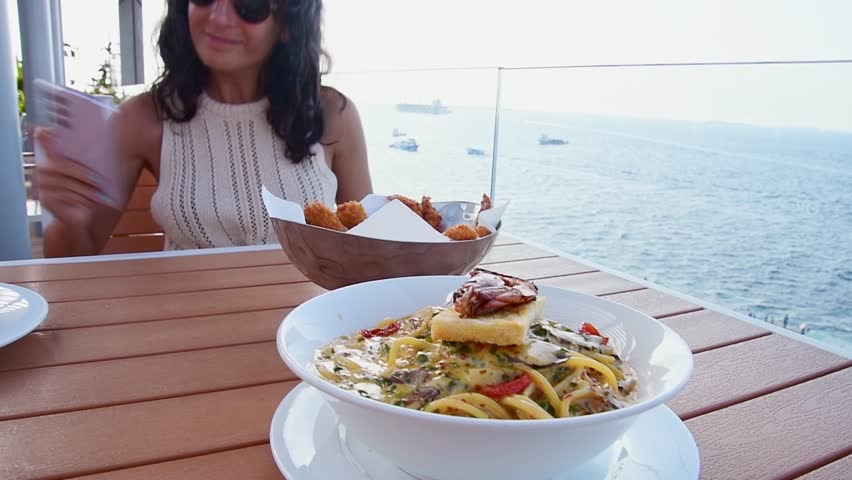 Male, Maldives - 10th may, 2024: tourist sit eat local dish in restaurant .Italian style spaghetti pasta meal with various herbs and tomatoes and grilled shrimp. Maldives cuisine